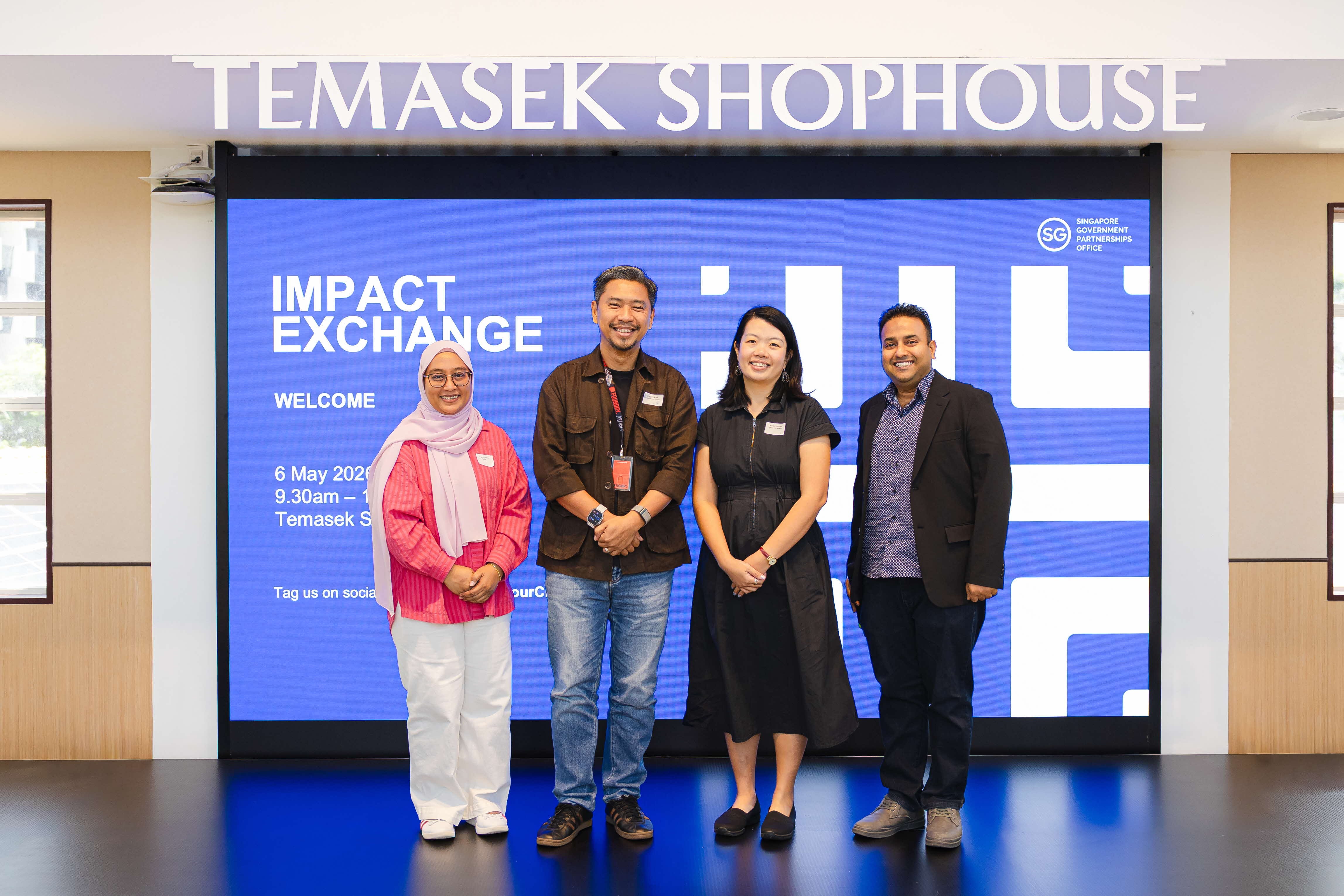 A group of panellists on stage engaged in a panel discussion at Impact Exchange.